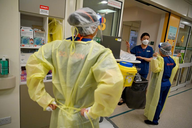  ​Medical staff donning protective equipment at a Singapore General Hospital isolation ward in November 2021. ST PHOTO LIM YAOHUI