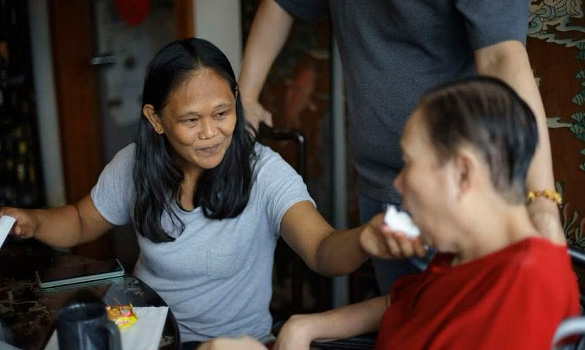  ​Ms Sosima Donato (right), who helps look after Madam Kow Whatt Neo, said she learned how to care for the elder woman by watching nurses and therapists. ST PHOTO ONG WEE JIN 