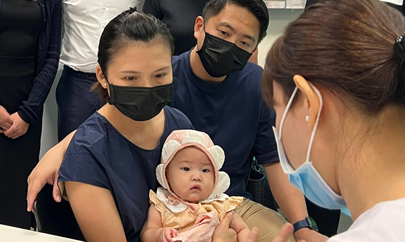  ​A family with their 4 month's old baby in a consultation with a nurse. Image source SingHealth Polyclinics 